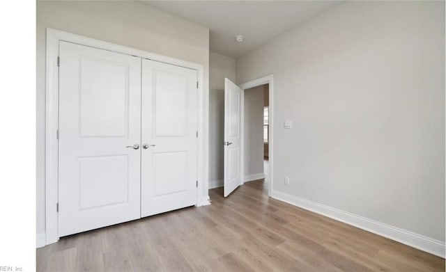 unfurnished bedroom with light hardwood / wood-style flooring and a closet