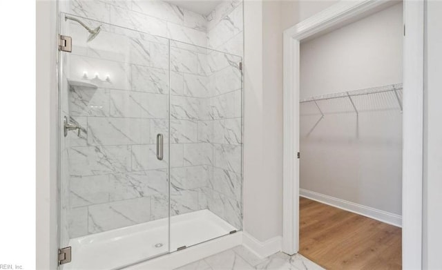 bathroom with a shower with door and wood-type flooring