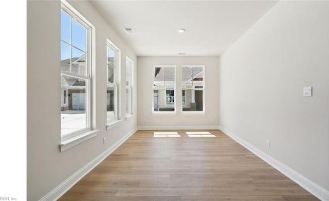 spare room featuring plenty of natural light and light hardwood / wood-style flooring