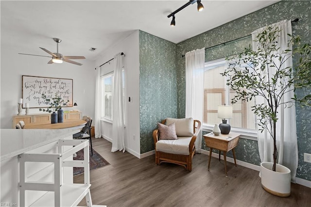 sitting room with ceiling fan, track lighting, and dark hardwood / wood-style floors