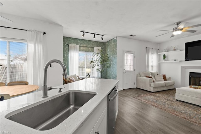 kitchen featuring dark hardwood / wood-style flooring, stainless steel dishwasher, ceiling fan, sink, and white cabinets