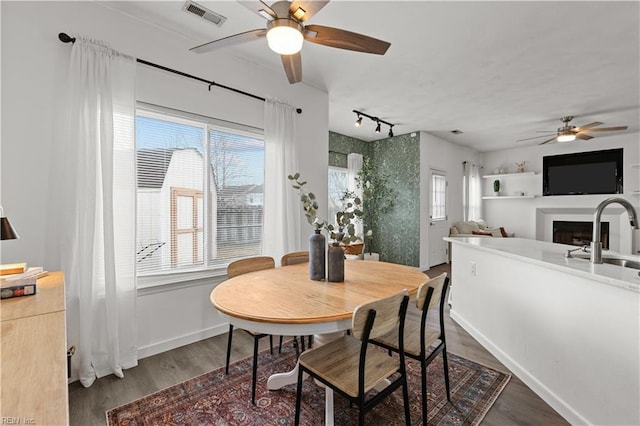 dining space featuring ceiling fan, dark hardwood / wood-style floors, plenty of natural light, and sink