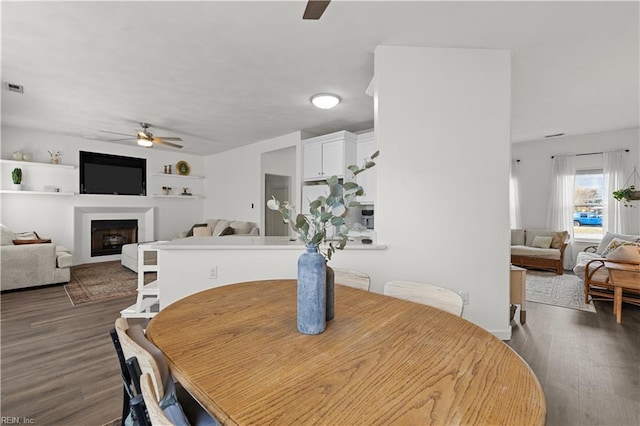 dining room with ceiling fan and dark hardwood / wood-style flooring