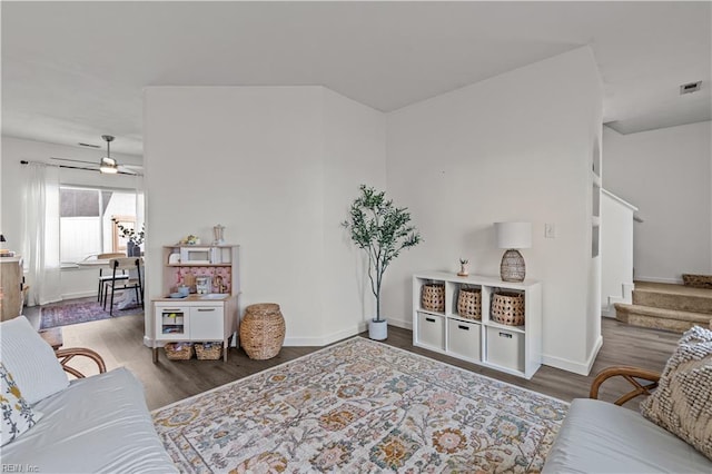 living room featuring ceiling fan and dark hardwood / wood-style flooring