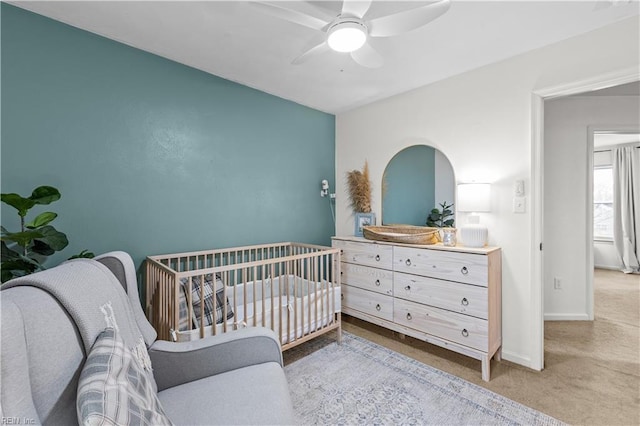 bedroom featuring a crib and ceiling fan