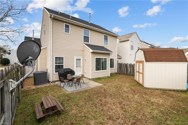 rear view of house with central AC, a patio area, a yard, and a storage shed