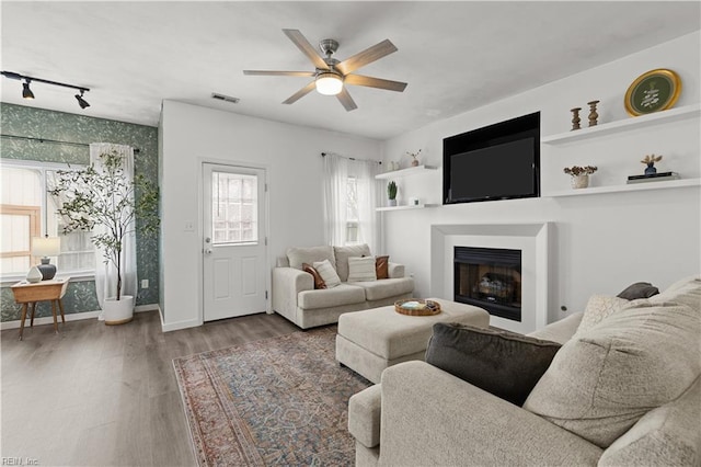 living room with rail lighting, hardwood / wood-style flooring, and ceiling fan