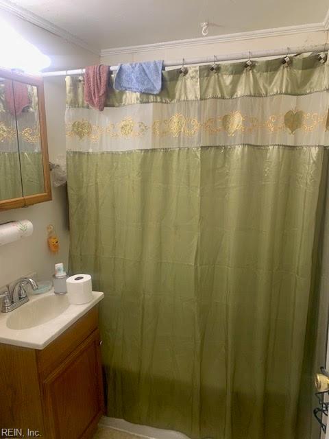 bathroom featuring a shower with curtain, vanity, and crown molding