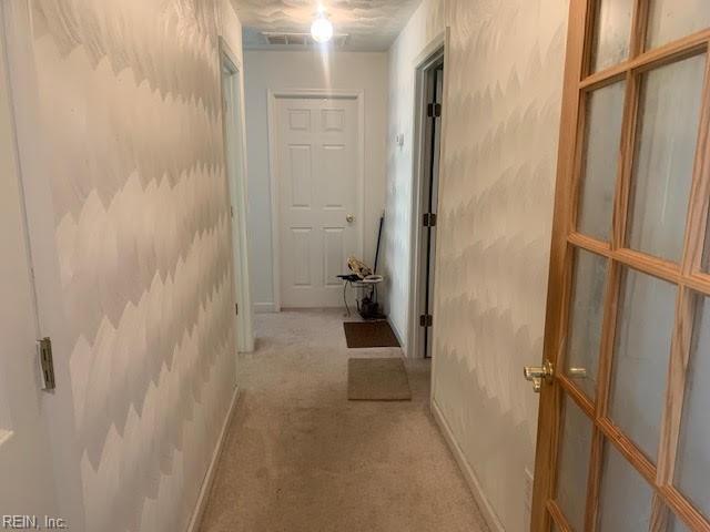 corridor with light colored carpet