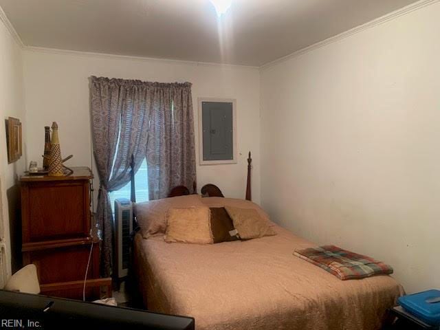 bedroom featuring electric panel and ornamental molding