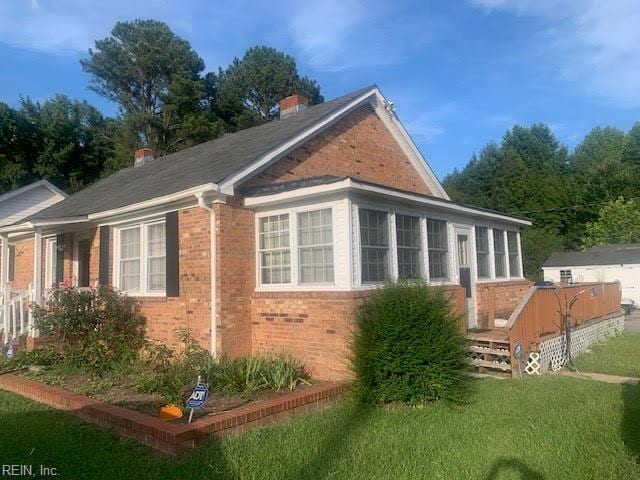 view of side of home with a yard and a wooden deck