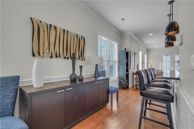 interior space featuring light hardwood / wood-style flooring, plenty of natural light, and ornamental molding