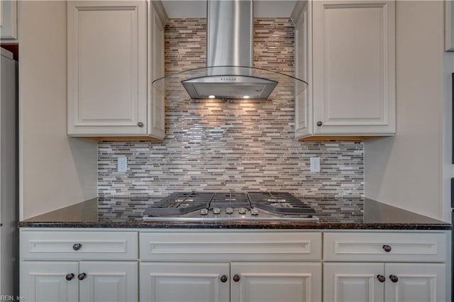 kitchen featuring tasteful backsplash, white cabinetry, wall chimney range hood, and stainless steel gas cooktop