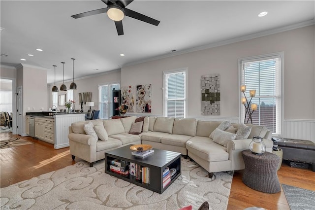 living room featuring ceiling fan, light hardwood / wood-style floors, and ornamental molding