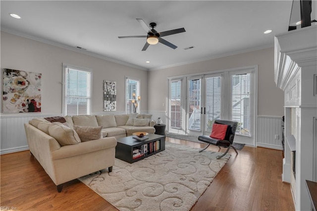 living room with hardwood / wood-style flooring, plenty of natural light, ceiling fan, and ornamental molding