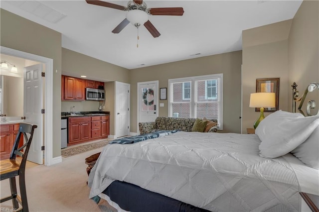 bedroom featuring ensuite bathroom, sink, ceiling fan, white fridge, and light colored carpet