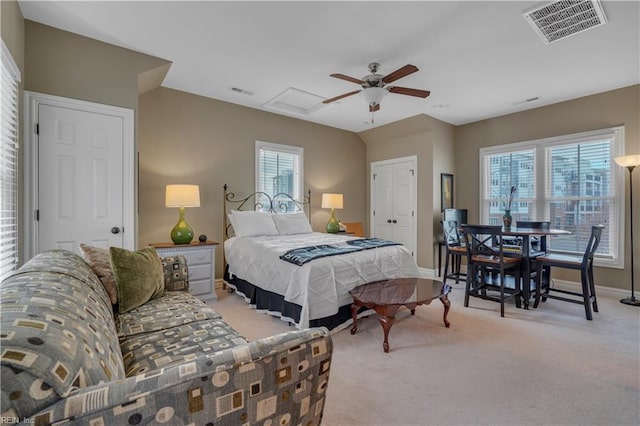 bedroom featuring ceiling fan, a closet, light colored carpet, and multiple windows