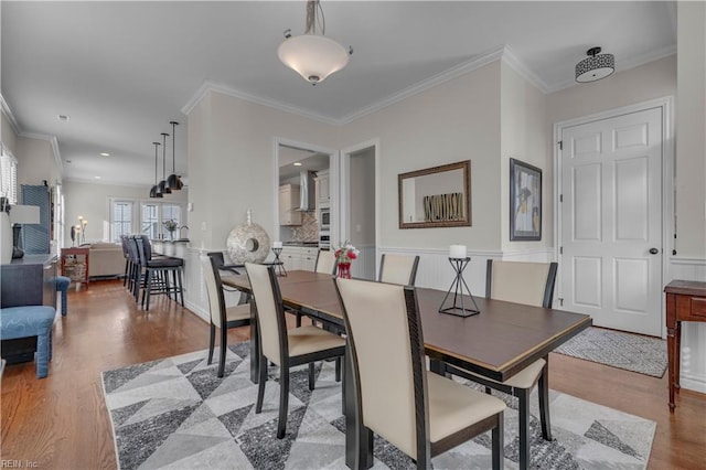 dining room with light hardwood / wood-style flooring and ornamental molding