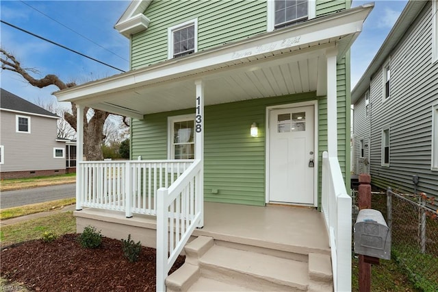 view of exterior entry featuring covered porch