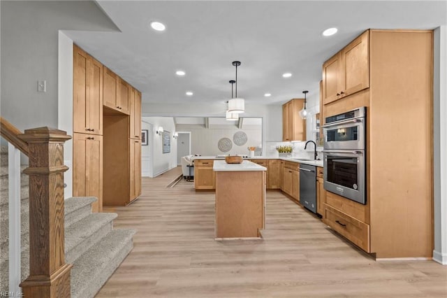 kitchen with pendant lighting, light wood-type flooring, stainless steel appliances, and a kitchen island