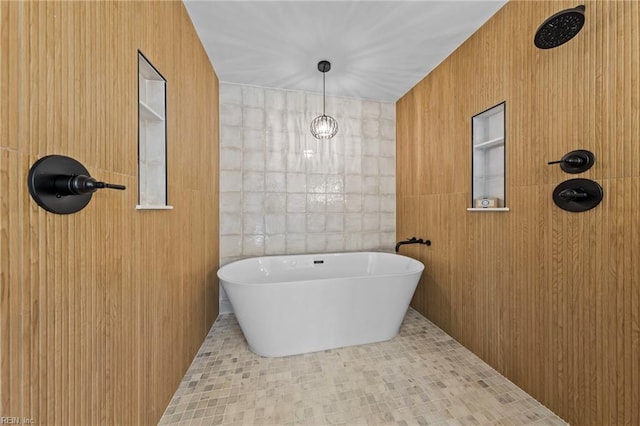 bathroom featuring tile patterned floors, a tub to relax in, and tile walls