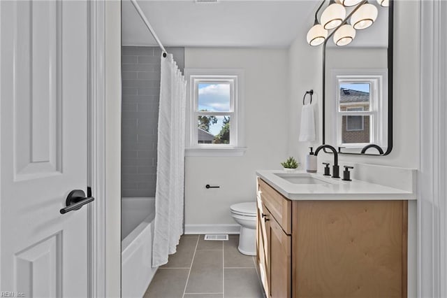 full bathroom featuring toilet, plenty of natural light, vanity, and tile patterned flooring