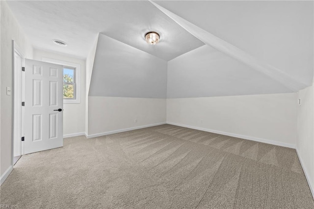 additional living space with light carpet and vaulted ceiling