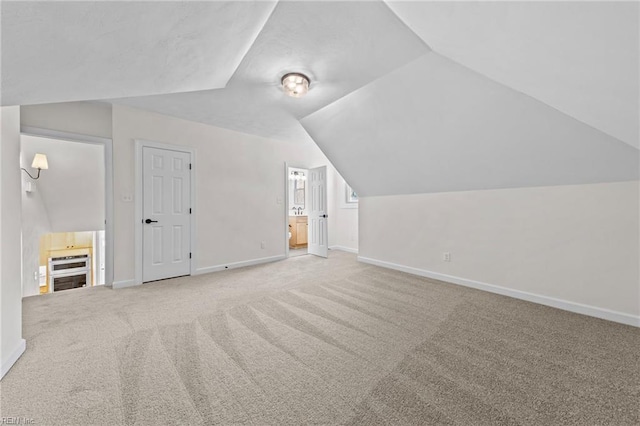 additional living space featuring carpet and lofted ceiling