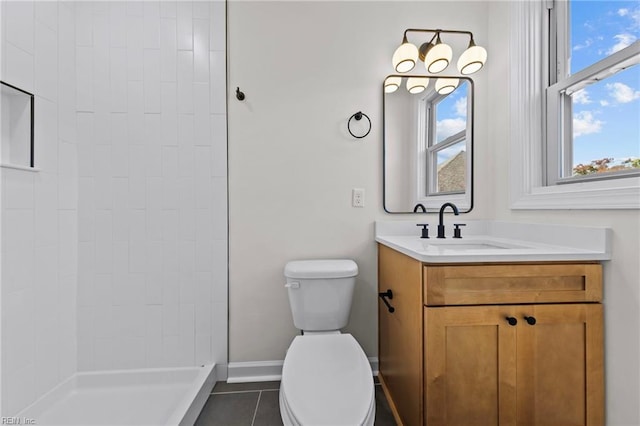 bathroom with tile patterned floors, vanity, toilet, and walk in shower