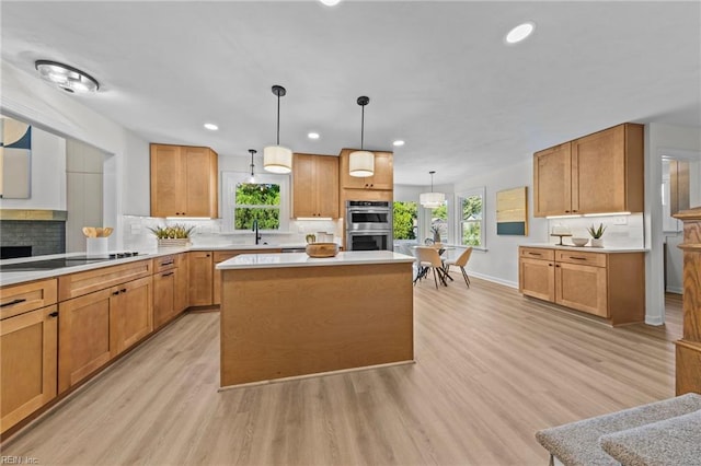 kitchen with tasteful backsplash, black electric cooktop, light hardwood / wood-style flooring, a kitchen island, and hanging light fixtures