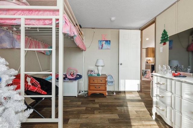 bedroom with a textured ceiling and dark hardwood / wood-style floors