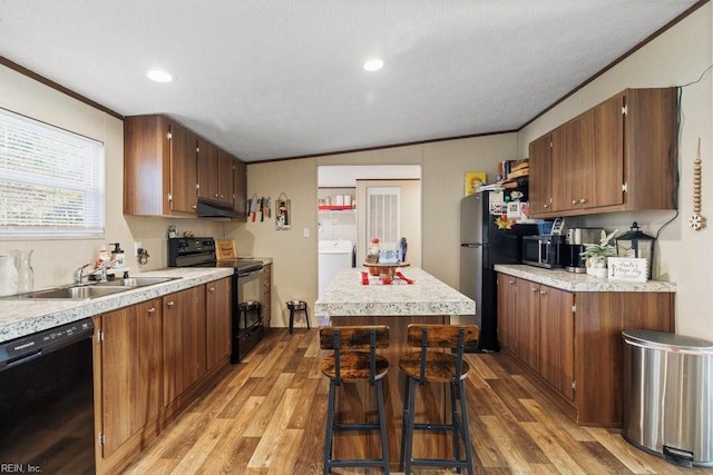 kitchen with crown molding, sink, black appliances, and light hardwood / wood-style floors