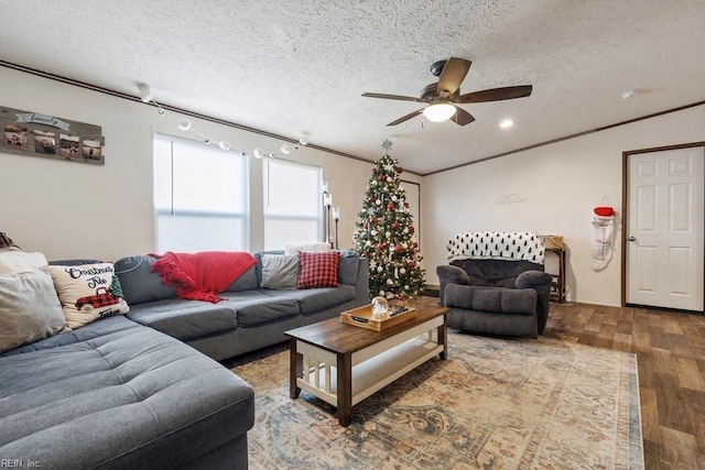 living room featuring ceiling fan, ornamental molding, a textured ceiling, and hardwood / wood-style flooring