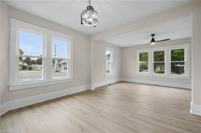 interior space with light hardwood / wood-style flooring and ceiling fan with notable chandelier