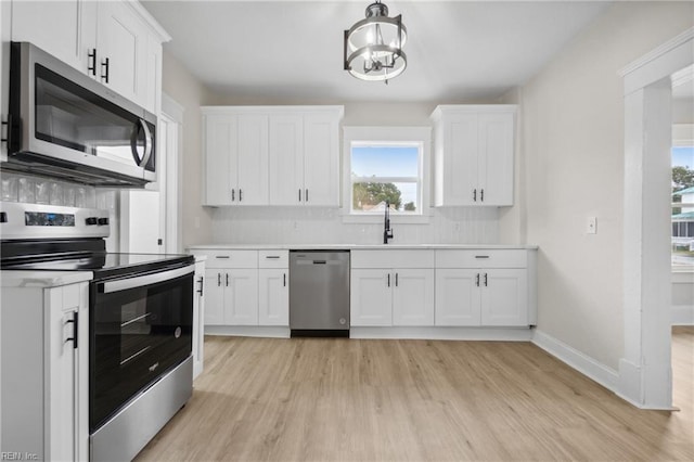 kitchen with decorative backsplash, sink, white cabinets, and stainless steel appliances