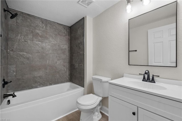 full bathroom with hardwood / wood-style flooring, vanity, tiled shower / bath combo, and toilet