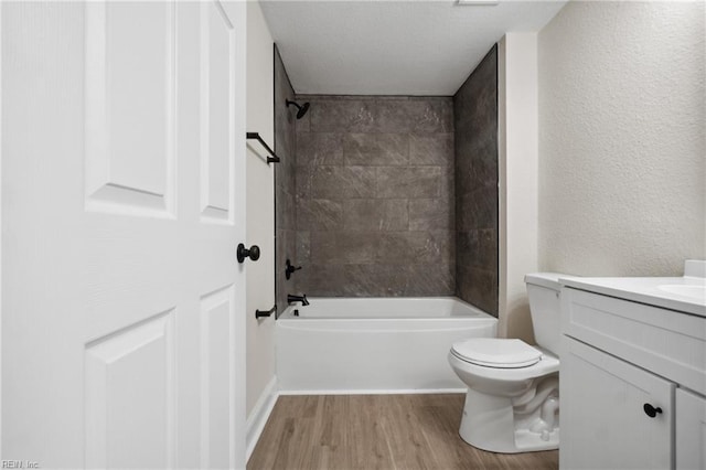 full bathroom featuring hardwood / wood-style floors, vanity, toilet, and tiled shower / bath combo