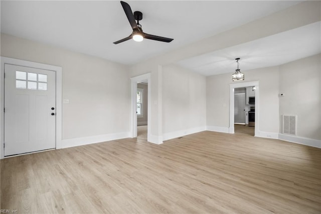 interior space featuring ceiling fan with notable chandelier and light wood-type flooring