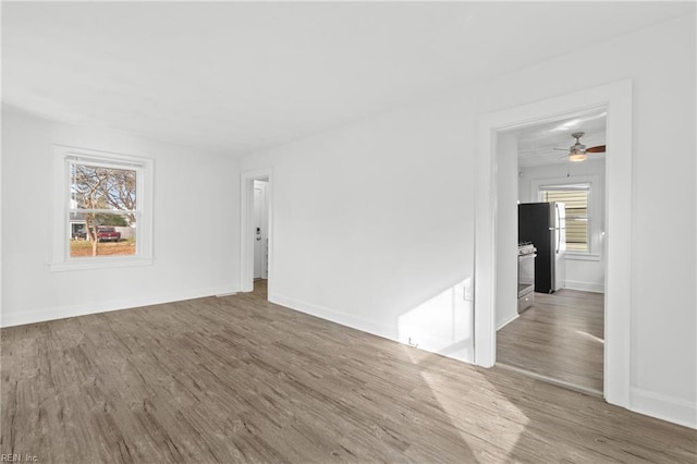 empty room with hardwood / wood-style floors and ceiling fan