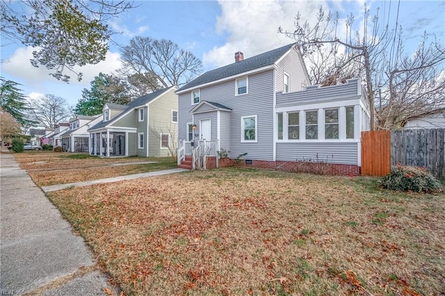 view of front of home featuring a sunroom and a front yard