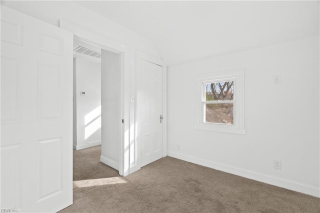 carpeted spare room with lofted ceiling