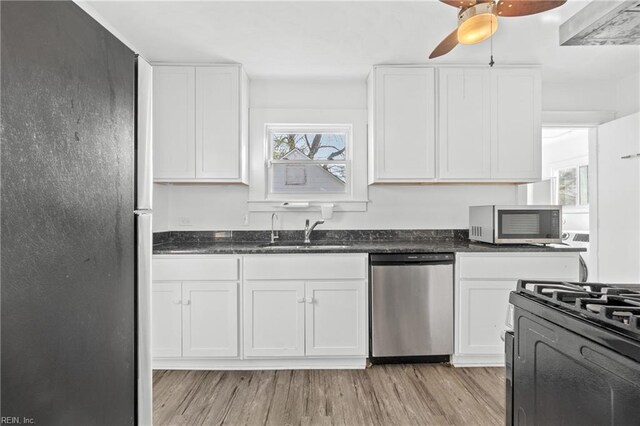 kitchen with white cabinets, light wood-type flooring, sink, and appliances with stainless steel finishes