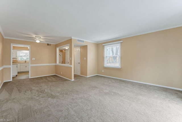 carpeted empty room with crown molding, plenty of natural light, and ceiling fan