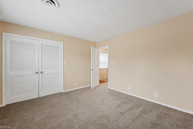 unfurnished bedroom featuring light carpet and a closet