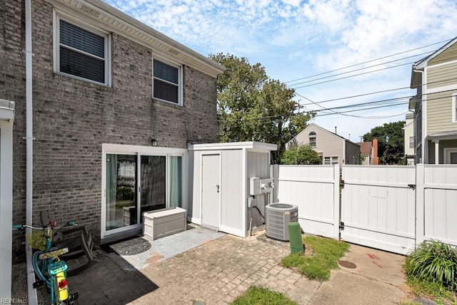 view of patio with central AC unit and a shed