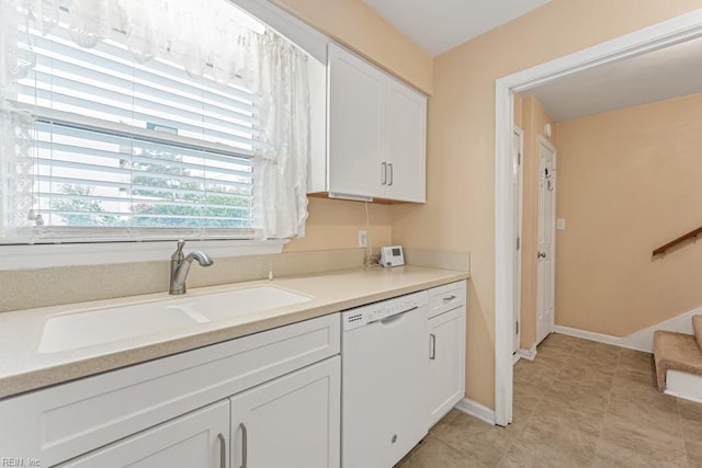 kitchen with white cabinets, white dishwasher, and sink