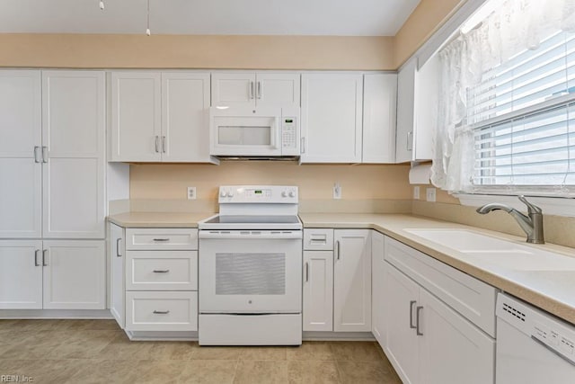 kitchen featuring sink, white cabinets, and white appliances