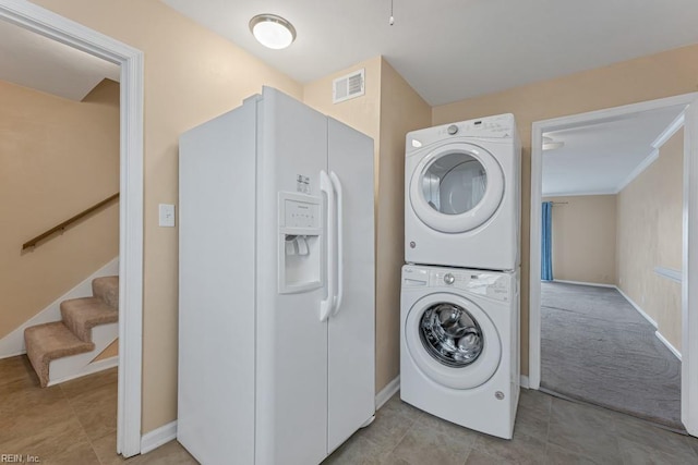 clothes washing area with stacked washer and clothes dryer