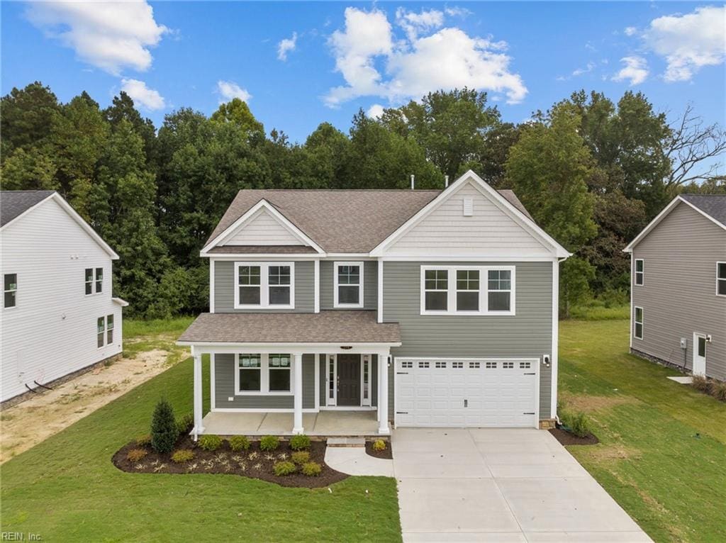 view of front of property featuring a garage, covered porch, and a front lawn