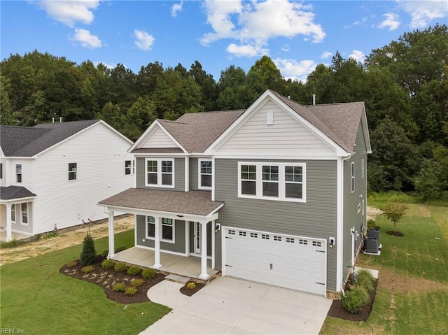 view of front of property with central air condition unit, a front yard, a porch, and a garage